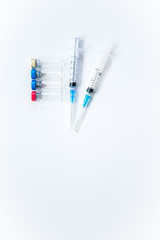 Veterinary and medical glass vials and two syringes for vaccination on a white isolated background. Liquid drug or vaccine to treat people and Pets against viruses, diseases, flu, rabies. Copy spase