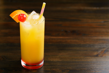 Tequila sunrise in collins glasses garnished with orange slice and cherry