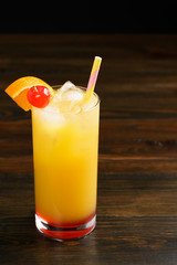 Tequila sunrise in collins glasses garnished with orange slice and cherry