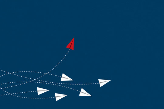 Think differently concept. Red airplane changing direction. New idea, change, trend, courage, creative solution, innovation and unique way concept.