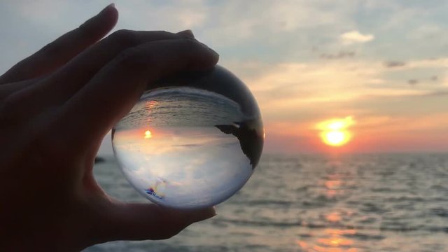 hand holding magic crystall ball over beautiful nature landscape, travel concept