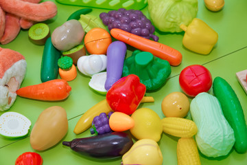 Fake fruits and vegetables .Plastic childrens toys in the form of fruit and vegetables . Toy fruits and grasszs .