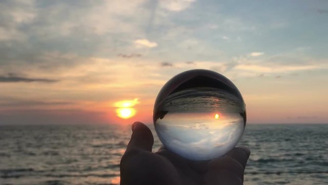 hand holding magic crystall ball over beautiful nature landscape, travel concept