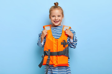 Preschool girl wears protective orange lifejacket, has awesome entertaining cruise, has fun on...