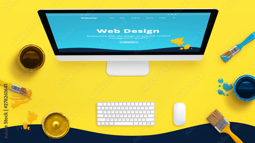 Poster Creative yellow web design studio desk with color brushes and boxes and painted web theme layout on a computer display.