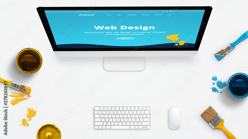 Leinwandbilder Concept of a modern web design studio with color brushes and color boxes on a clean desk. Modern web site on computer display painted with colors.