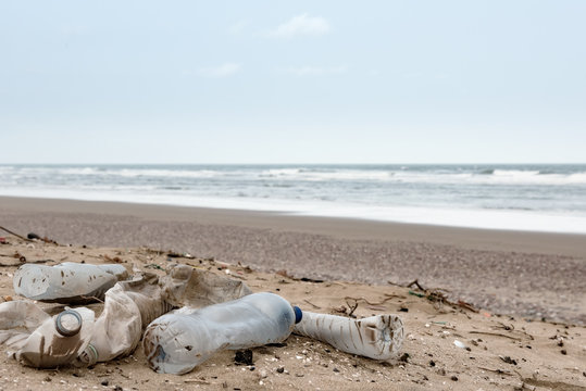 Beach pollution. Plastic bottles and other trash on sea beach