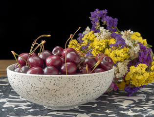 Delicious juicy cherries,lying on a beautiful plate.On wood background