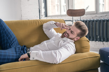 Worried businessman with headache lying on couch in living room