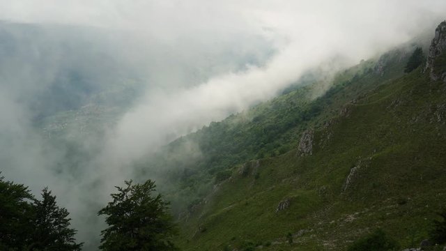 Fog slowly moves by mountain - (4K)