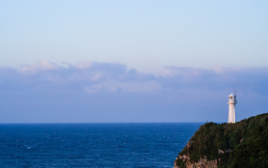 Fototapeta na wymiar Morning sea and lighthouse standing on the quay