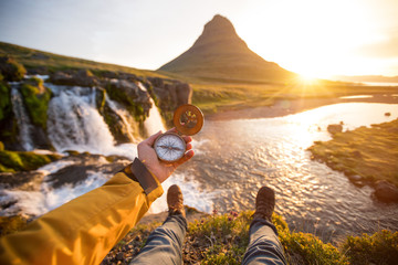 Beautiful landscape with old compass on traveler's hand. Traveling concept.