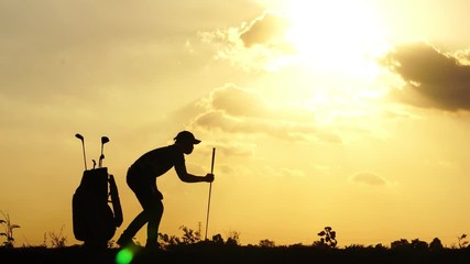 Silhouette male golfers were practicing outside with the sun sets, footage 4K