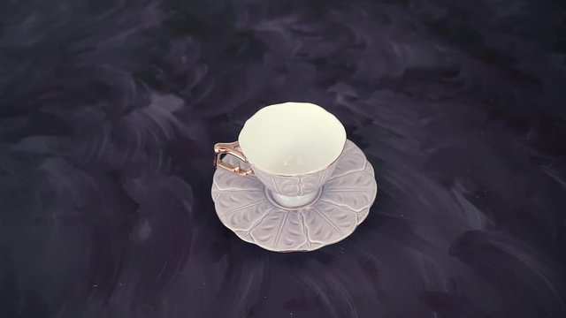 Pouring Turkish coffee on purple background. Traditional Turkish drink with caffeine