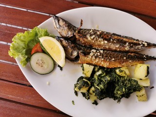 cooked mackerel fish meal with spinach on the top