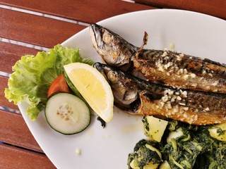 cooked mackerel fish meal with spinach on the top