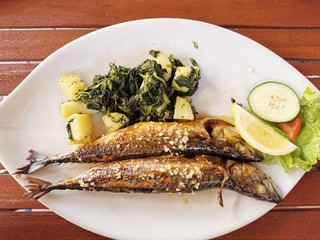 cooked mackerel fish meal with spinach on the top