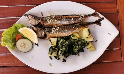 cooked mackerel fish meal with spinach on the top