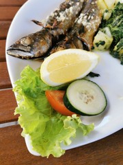 cooked mackerel fish meal with spinach on the top