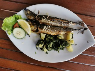cooked mackerel fish meal with spinach on the top