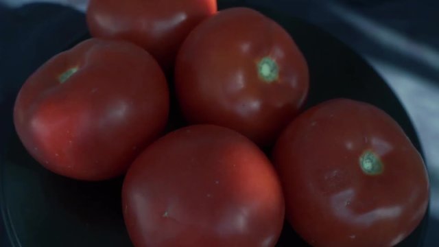 Fresh ripe tomatoes rotating on back background. Group of tomatoes