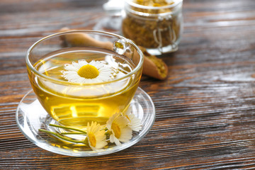 Cup of hot chamomile tea on wooden table