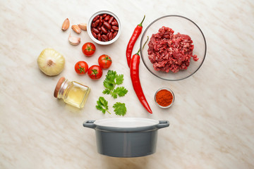 Ingredients for chili con carne with pot on light background