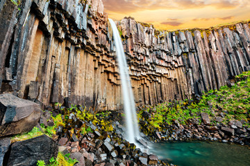 Sunset over beautiful Svartifoss waterfall. Location Skaftafell National Park, Vatnajokull glacier, Iceland, Europe.