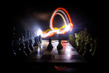 Chess board game concept of business ideas and competition. Chess figures on a dark background with smoke and fog.