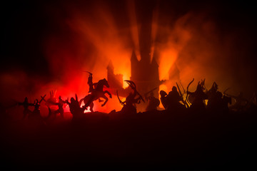 Medieval battle scene with cavalry and infantry. Silhouettes of figures as separate objects, fight between warriors on dark toned foggy background with medieval castle.