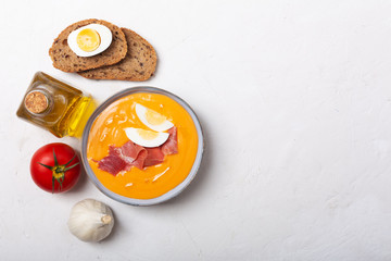 Salmorejo cordobes typical spanish tomato soup similar to the gazpacho, topped with jamon serrano and eggs, white background