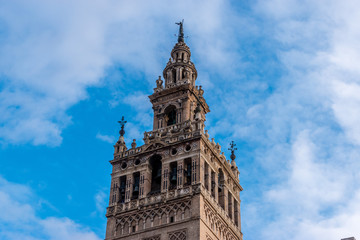 Fototapeta na wymiar The Giralda is a bell tower of Seville Cathedral in Spain. It was built as the minaret for the Great Mosque of the Sevilla in Al-Andalus, Moorish Spain during the reign of the Almohad dynasty.