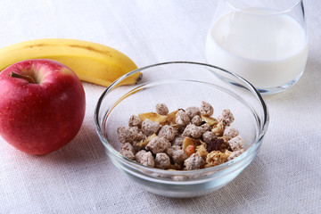 Healthy food with Corn Flakes cereal in a bowl, apple, banana and glass with milk. Morning breakfast.