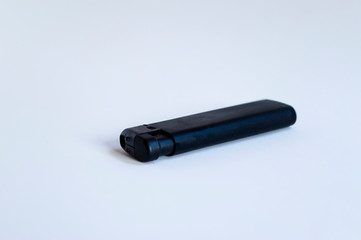 Open front shoot of horizontal black lighter on white surface