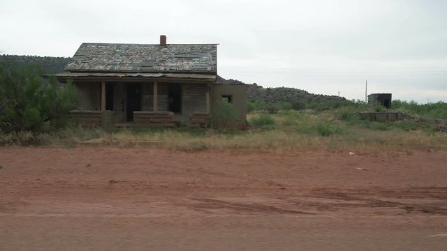 Driving POV past an old run down house