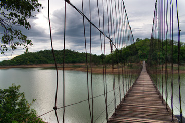 Obraz premium Hanging Bridge over the reservoir at sunset, Kang Krajarn National Park, Petchaburi, Thailand