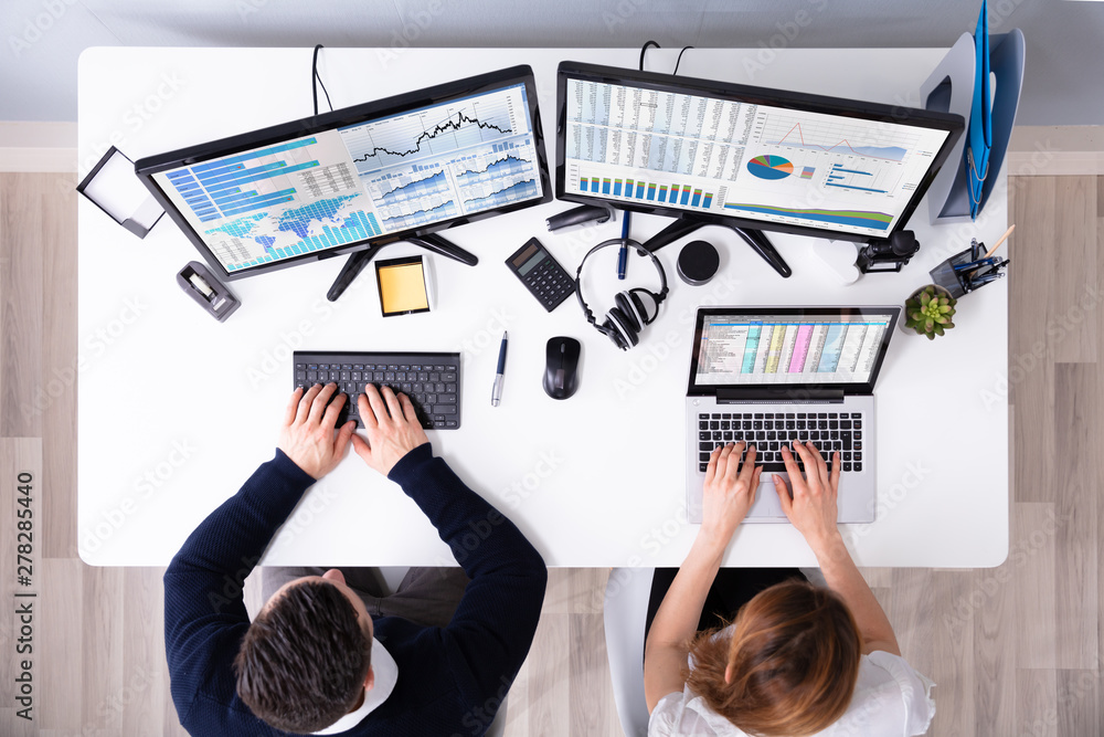 Poster two businesspeople examining graph on computer