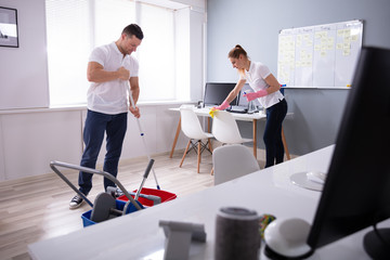 Smiling Two Young Janitor Cleaning The Office