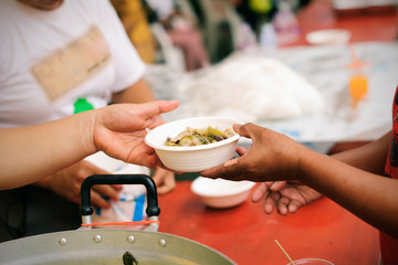 The hands of beggars receive donated food : The concept of food shortages