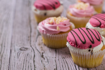 A few cupcakes on a wooden table.