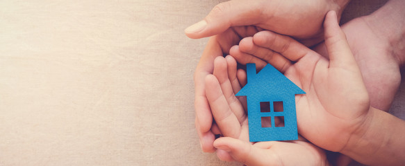 hands holding paper house, family home, homeless shelter, international day of families, foster home care, family day care, social distancing, stay at home, housing mortgage crisis concept - obrazy, fototapety, plakaty