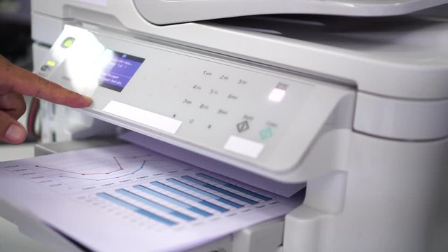 Documents printing concept : Business man hand pressing button machine supplies in control panel laser printer for copy scanner and printing document report graph chart in busy office 