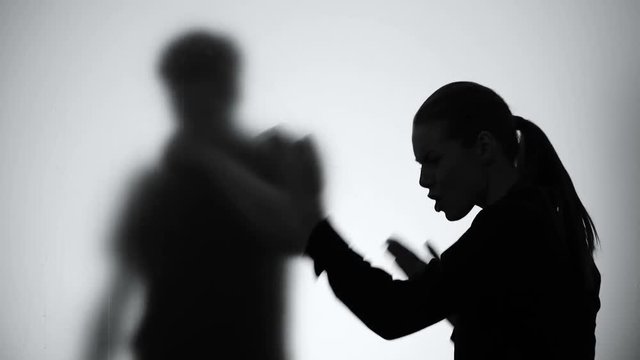 Silhouette of woman shouting on drunk husband through glass, alcohol problems