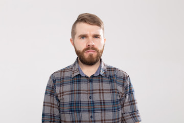 Portrait of doubtful bearded man wearing casual plaid shirt, looking with indecisive expression on...