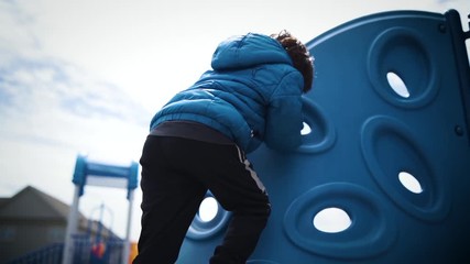 Young boy climbing a jungle gym in slow motion