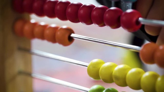 Young boy counting with a colourful abacus in slow motion