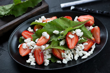 Salad with beetroot leaves, fresh strawberries and cottage cheese, selective focus, studio shot