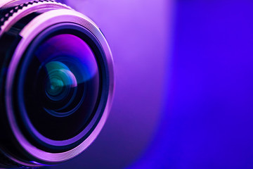 Camera lens with purple backlight. Side view of the lens of camera on purple background. Purple camera Lens close Up. © borislav15