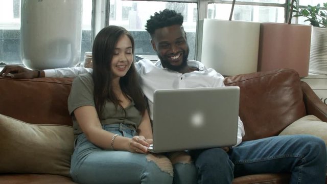 Young Couple Video Chatting On Laptop At Home