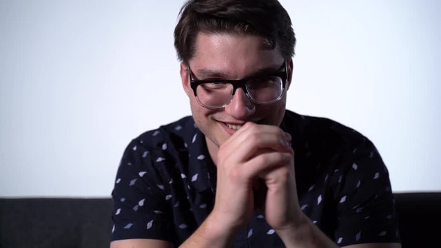 Caucasian Male Starring with Creepy Eyes at Camera Fiddling Fingers